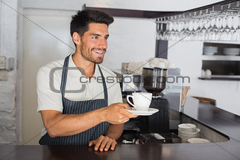 Barista holding cup of coffee at the café