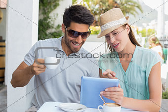 Young couple using digital tablet at café