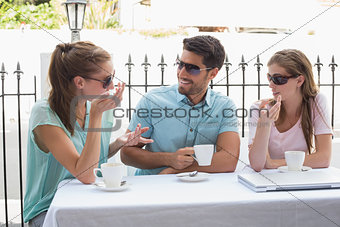 Three happy friends having coffee in café