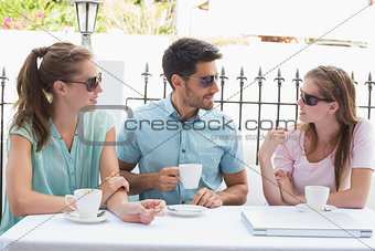 Happy friends having coffee in café