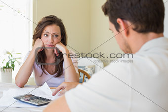 Upset young woman and man with home bills