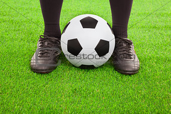Soccer player's feet with ball  on an open playing field