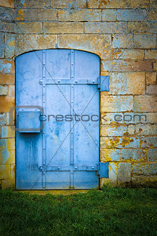 Old blue metal door set in stone