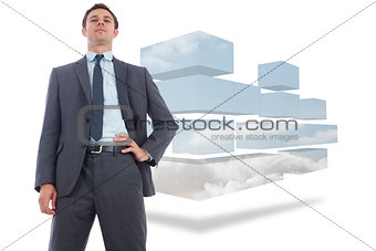 Composite image of stern businessman with hand on hip