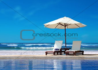 Two Chairs with White Umbrella near the Beach