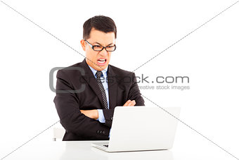 angry businessman look at laptop and cross arms