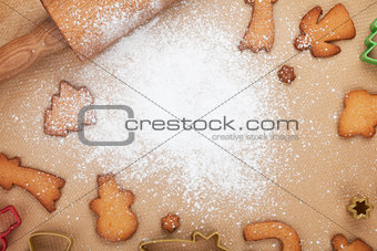 Rolling pin and gingerbread cookies on cooking paper