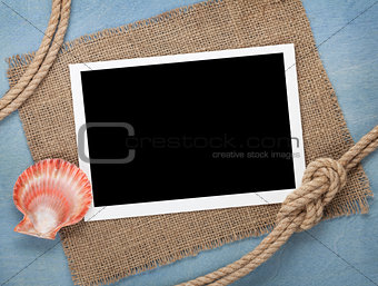 Blank photo frame with seashell and ship rope