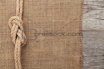 Ship rope on wood and burlap texture background
