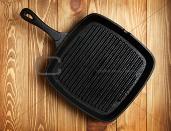 Frying pan on wooden table background