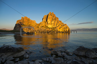 Shaman Rock in the rays of the rising sun. Olkhon Island, Baikal