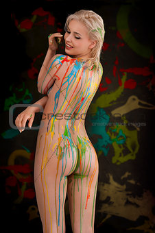 blond nude girl with multicolor over her body smiling with sexy 