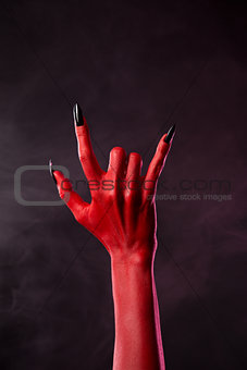 Red devil hand showing heavy metal gesture 