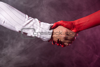 Businessman making an agreement with devil 