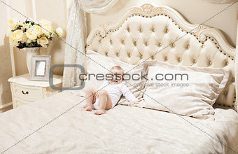 Little boy lying on bed at home and smiling