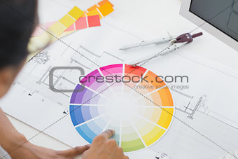Interior designer looking at colour wheel at desk