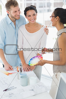 Interior designer showing colour wheel to happy clients