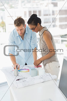 Interior designers looking at colour wheel and blueprints
