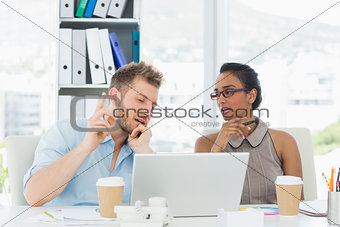Partners working together at desk on laptop