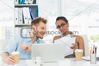 Partners working together on laptop at desk