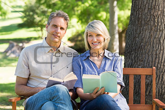 Couple with books sitting on bench