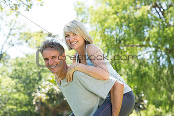 Couple enjoying piggyback ride in park