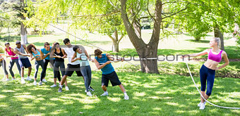 Woman playing tug of war with friends