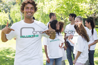 Portrait of volunteer pointing at tshirt