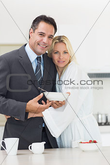 Portrait of a woman embracing well dressed man in kitchen