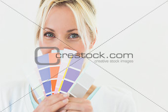 Closeup portrait of a beautiful woman holding color swatches
