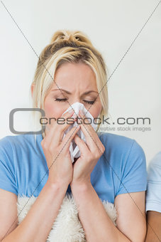 Closeup of a young woman suffering from cold