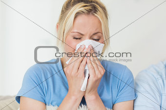 Closeup of a young woman suffering from cold