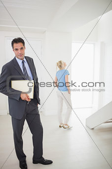Well dressed real estate agent with blurred woman in background
