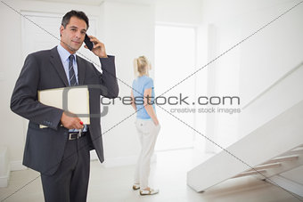 Real estate agent on call with blurred woman in background
