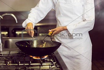 Mid section of a chef preparing food in kitchen