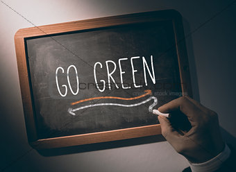 Hand writing go green on chalkboard