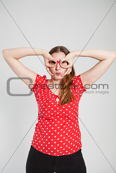 Attractive woman looking through finger goggles