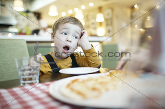 Young boy yawning as he waits to be fed