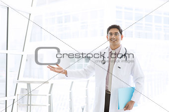 Asian Indian male medical doctor showing welcome hand sign