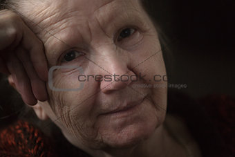 old woman thinking in the dark