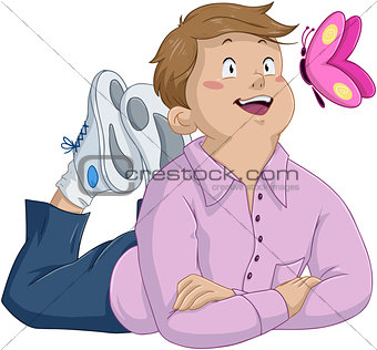 Innocent Brunette Boy Laying And Looking At Butterfly