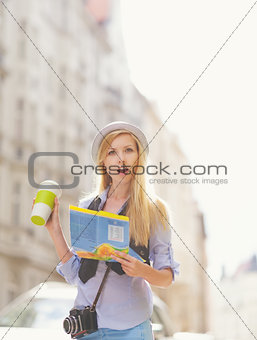 Surprised young woman tourist with map in the city