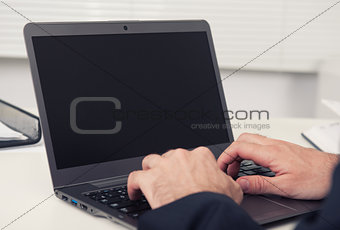 Rear view of a businessman working on a laptop