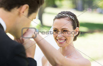 Groom kissing on hand of bride