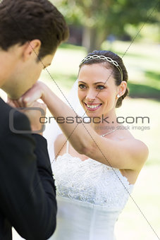Groom kissing on hand of beautiful bride