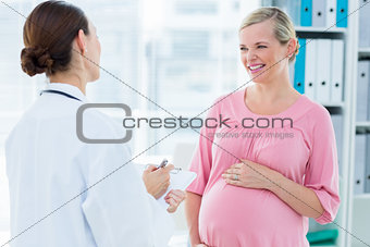 Pregnant woman discussing with female doctor