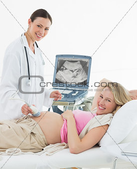 Doctor using ultrasound scanner on pregnant woman