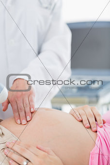 Doctor touching belly of pregnant woman