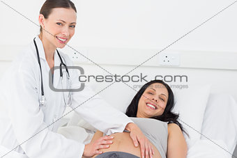 Beautiful doctor checking expectant woman