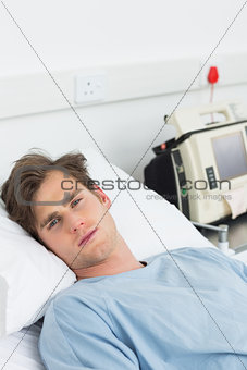 Sick man lying in hospital bed
